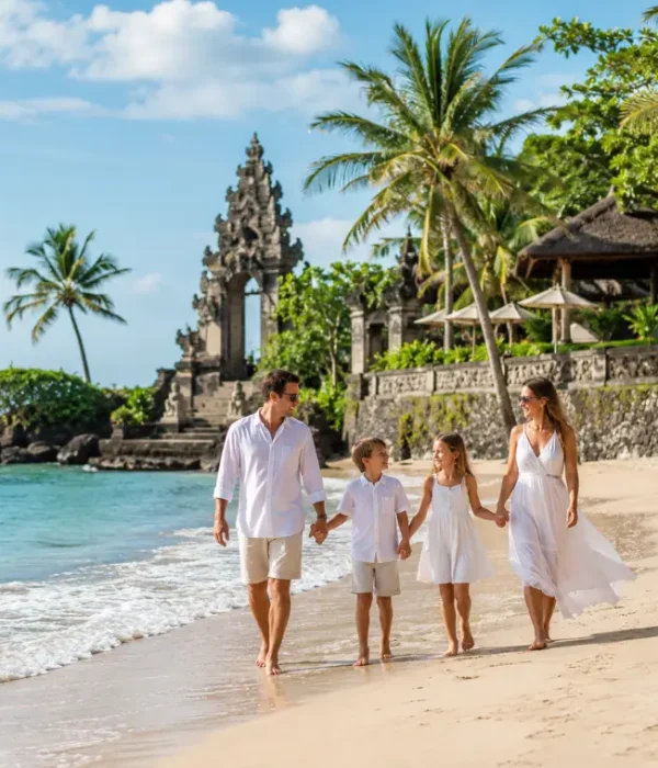 Family enjoying Bali beach with turquoise sea, golden sand, palm trees, and Balinese resort architecture.