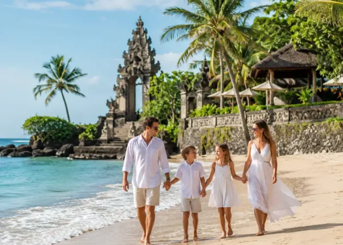 Family enjoying Bali beach with turquoise sea, golden sand, palm trees, and Balinese resort architecture.