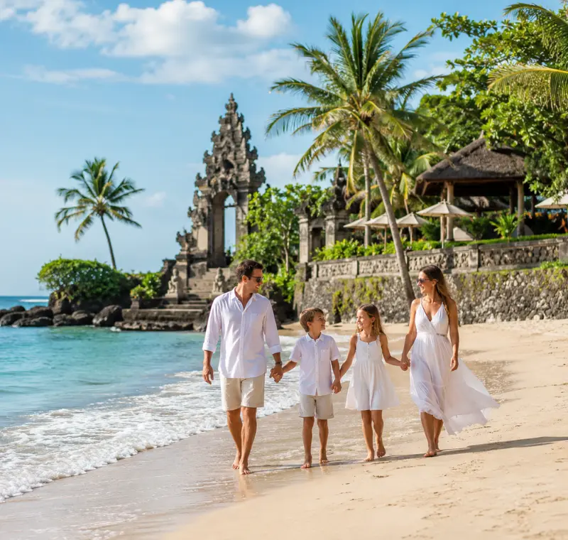 Family enjoying Bali beach with turquoise sea, golden sand, palm trees, and Balinese resort architecture.