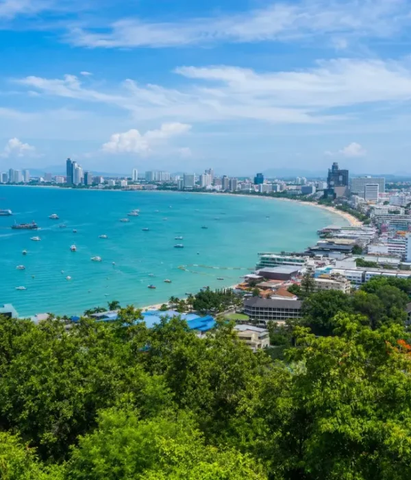 Pattaya Bay coastline with turquoise sea, beachfront skyline and tropical greenery in bright daytime
