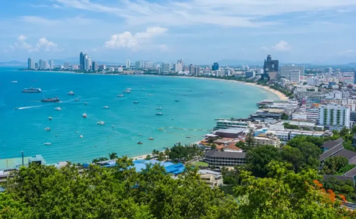 Pattaya Bay coastline with turquoise sea, beachfront skyline and tropical greenery in bright daytime