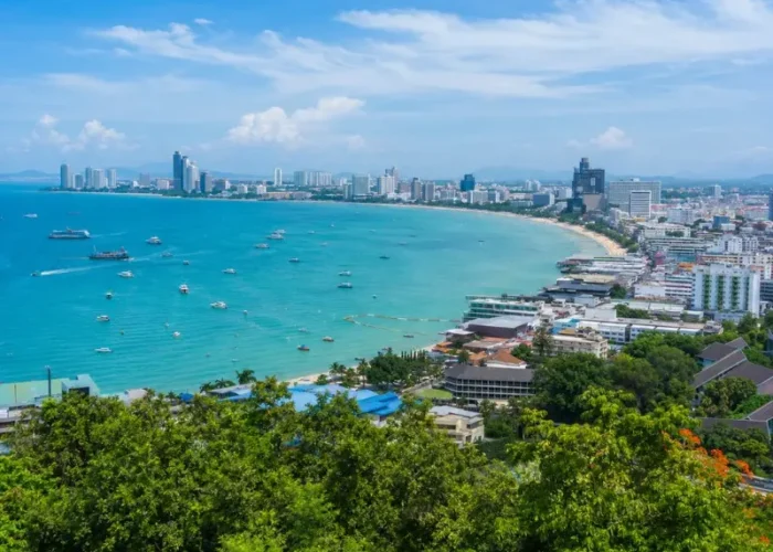 Pattaya Bay coastline with turquoise sea, beachfront skyline and tropical greenery in bright daytime