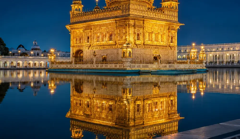 Golden Temple in Amritsar glowing at night with golden lights, calm water reflection, marble walkway, and a luxury spiritual travel atmosphere.
