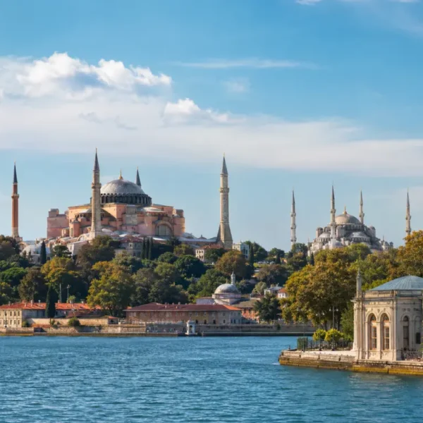 Bright daytime view of Istanbul with Hagia Sophia, Blue Mosque, historic skyline, and calm Bosphorus waterfront.