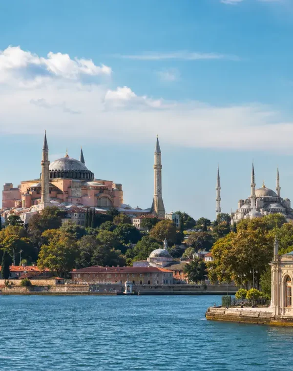 Bright daytime view of Istanbul with Hagia Sophia, Blue Mosque, historic skyline, and calm Bosphorus waterfront.