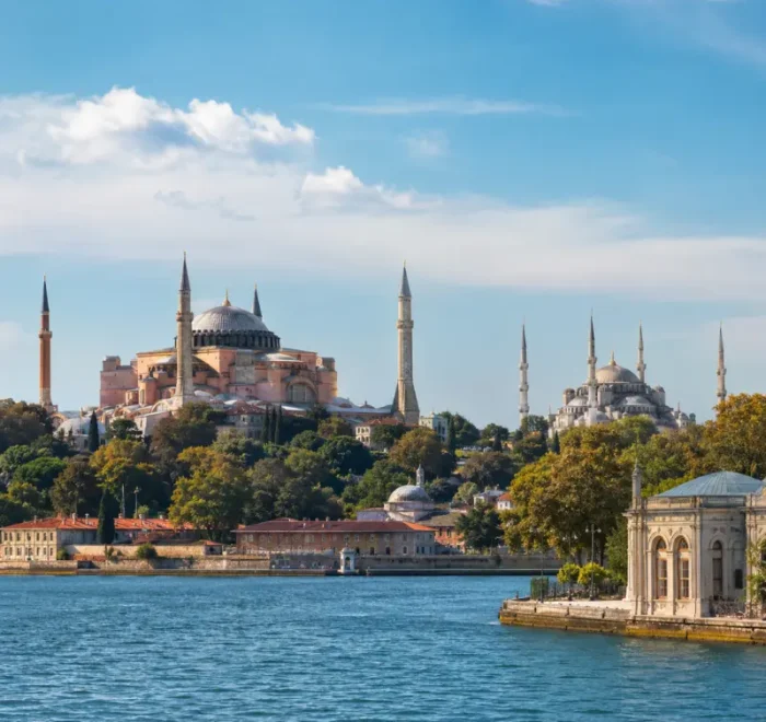 Bright daytime view of Istanbul with Hagia Sophia, Blue Mosque, historic skyline, and calm Bosphorus waterfront.
