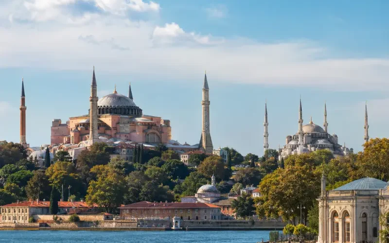 Bright daytime view of Istanbul with Hagia Sophia, Blue Mosque, historic skyline, and calm Bosphorus waterfront.