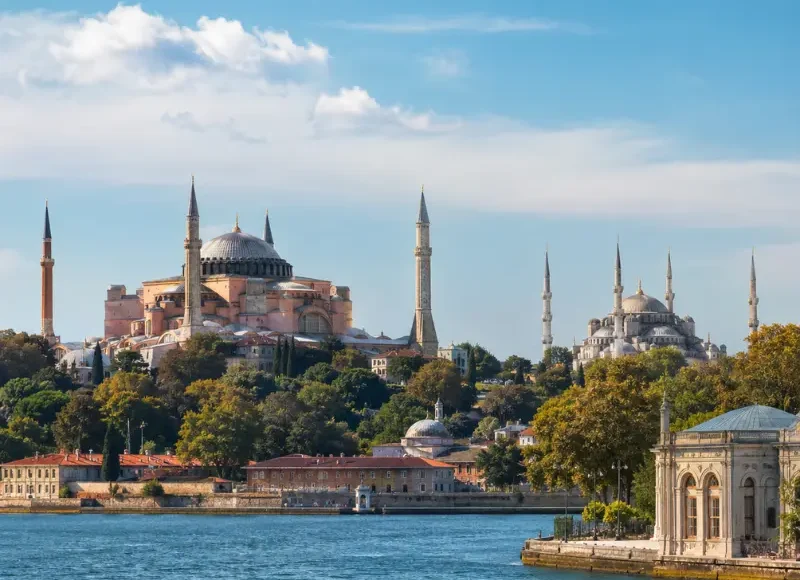 Bright daytime view of Istanbul with Hagia Sophia, Blue Mosque, historic skyline, and calm Bosphorus waterfront.