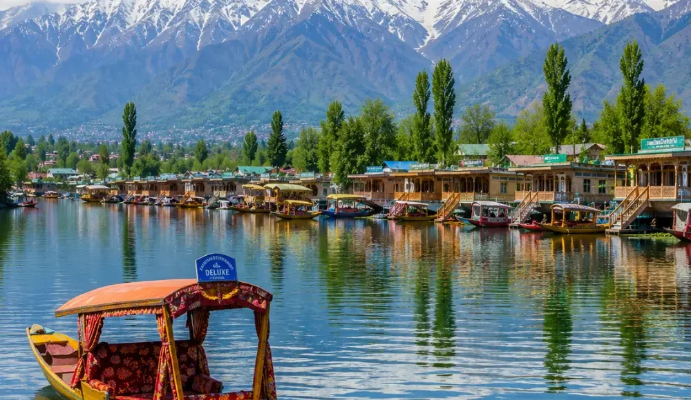 Srinagar with Dal Lake, shikaras, Mughal gardens, wooden houseboats and Himalayan mountains in clear morning light.