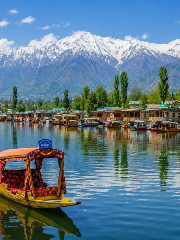 Srinagar with Dal Lake, shikaras, Mughal gardens, wooden houseboats and Himalayan mountains in clear morning light.