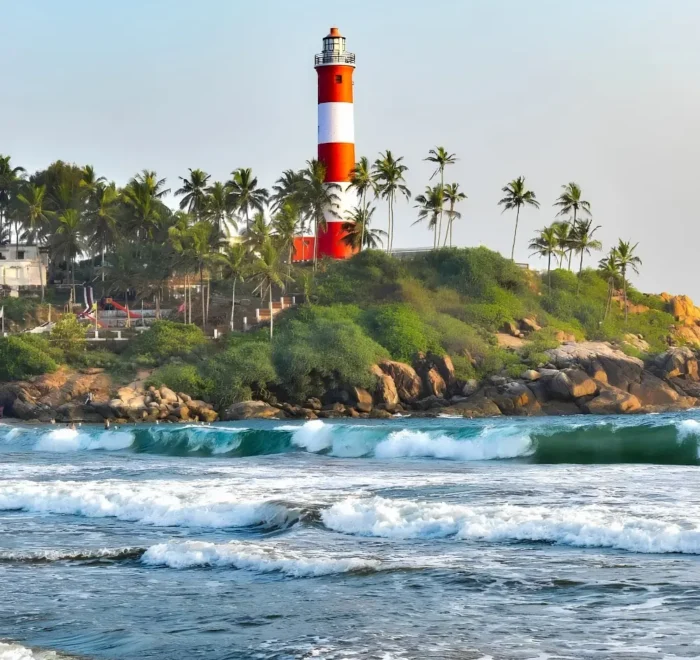 Munnar Thekkady Alleppey Kovalam package featuring Kovalam Lighthouse, palm-lined beach, sea waves and Kerala coastal beauty
