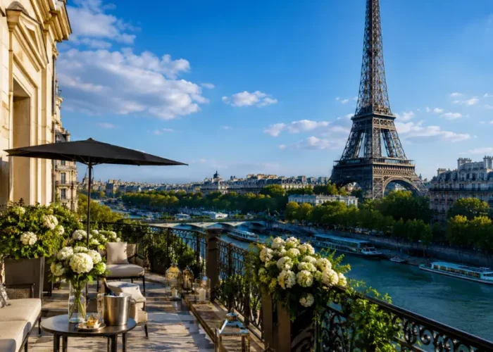 Luxury Paris terrace overlooking the Eiffel Tower, Seine River, elegant balcony seating, flowers, and clear blue sky.