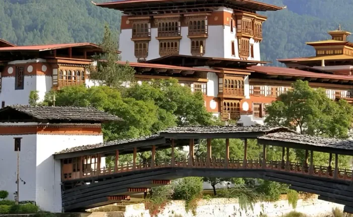 Punakha Dzong in Bhutan with traditional bridge, riverside architecture, forested mountains, and calm water.