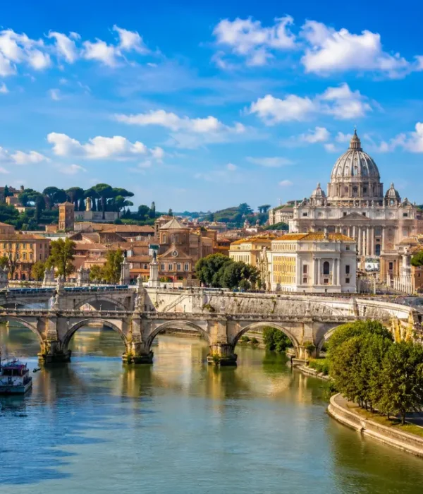 Rome skyline with St. Peter’s Basilica, historic bridge, Tiber River reflections, and warm golden evening light.