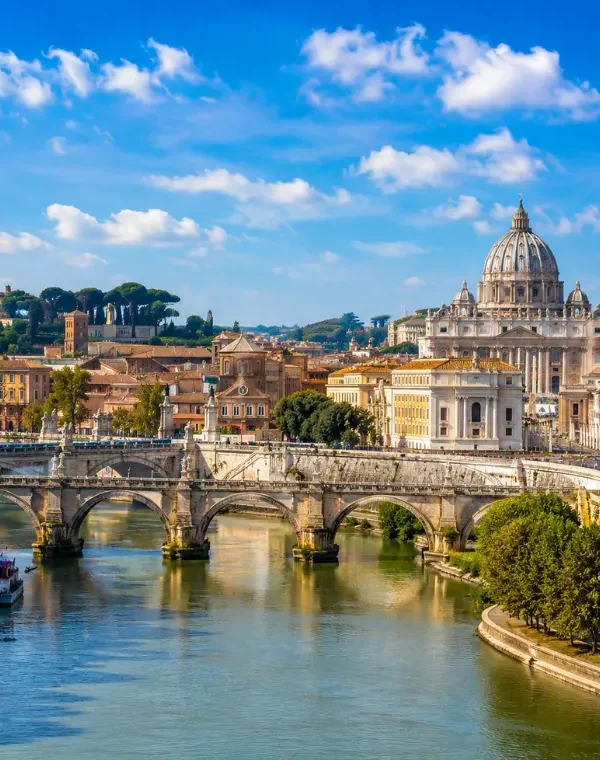 Rome skyline with St. Peter’s Basilica, historic bridge, Tiber River reflections, and warm golden evening light.