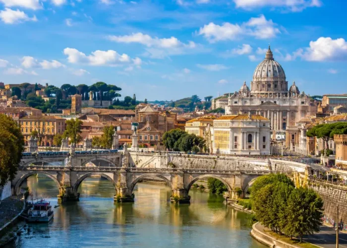 Rome skyline with St. Peter’s Basilica, historic bridge, Tiber River reflections, and warm golden evening light.