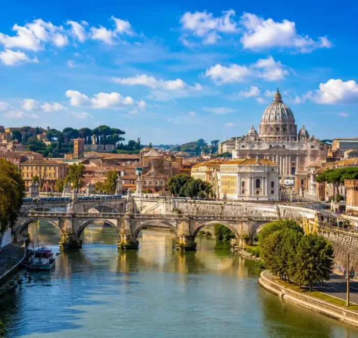 Rome skyline with St. Peter’s Basilica, historic bridge, Tiber River reflections, and warm golden evening light.