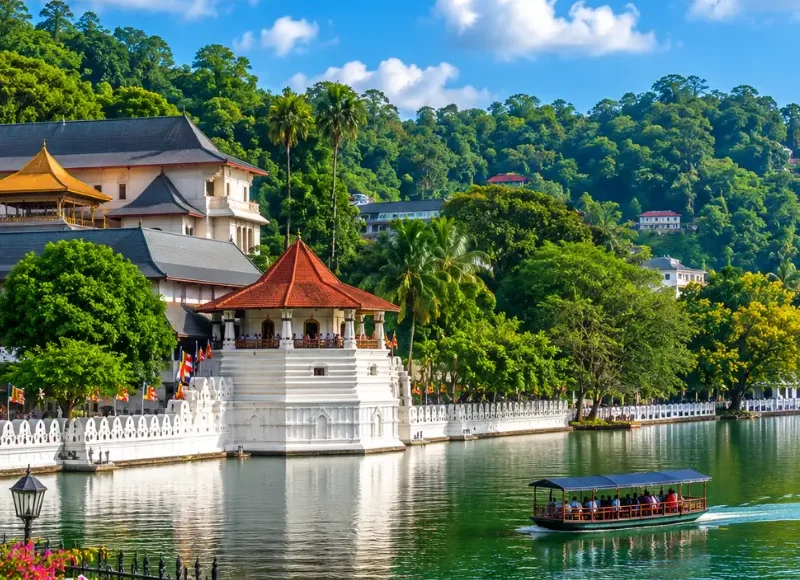 Bright daytime view of Kandy Sri Lanka with Kandy Lake, lush green hills, and the Temple of the Sacred Tooth Relic.