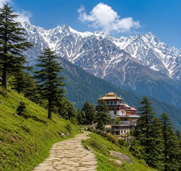 McLeodganj monastery surrounded by pine forests with snow-capped Dhauladhar mountains in Dharamshala, Himachal Pradesh