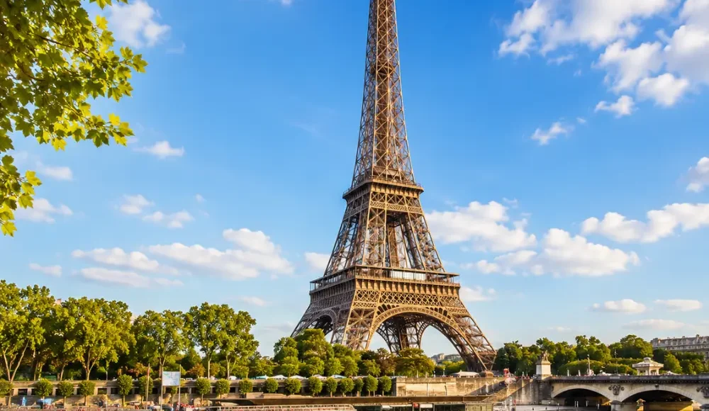 Eiffel Tower in Paris with elegant gardens, classic city views, clear sky, and bright morning European atmosphere.