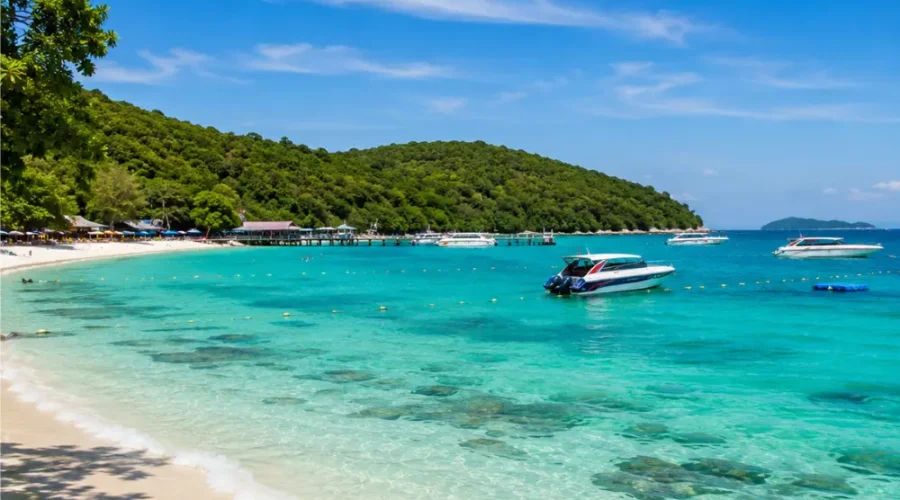 Pattaya Coral Island Thailand with turquoise sea, white sandy beach, speedboats, and bright morning tropical atmosphere.