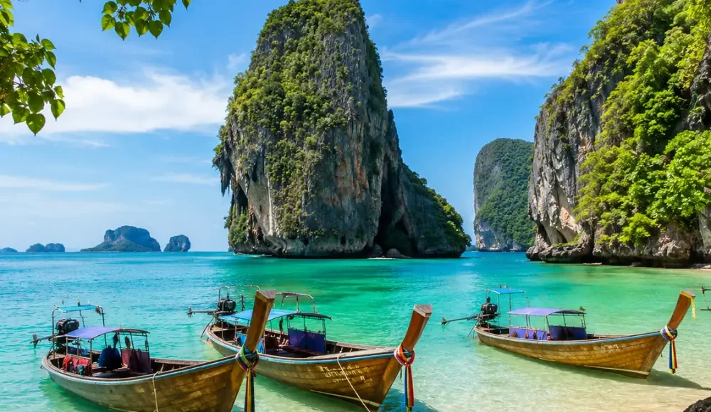 Krabi Thailand with limestone cliffs, turquoise sea, longtail boats, tropical beach, and bright morning island atmosphere.