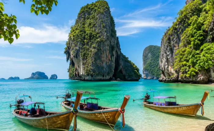 Krabi Thailand with limestone cliffs, turquoise sea, longtail boats, tropical beach, and bright morning island atmosphere.