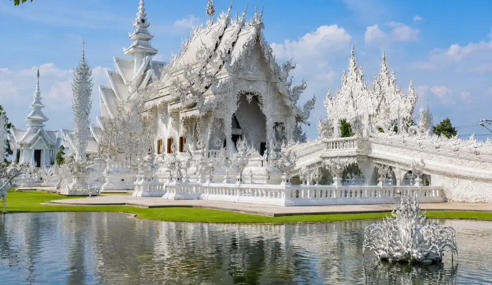 Chiang Rai Thailand with White Temple, ornate Thai architecture, lush gardens, and bright morning cultural atmosphere.