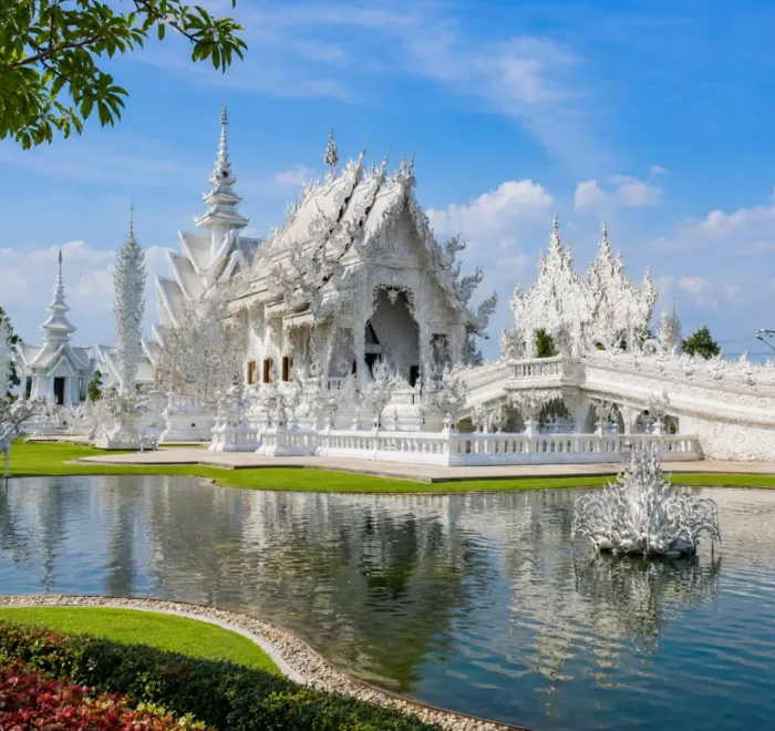 Chiang Rai Thailand with White Temple, ornate Thai architecture, lush gardens, and bright morning cultural atmosphere.