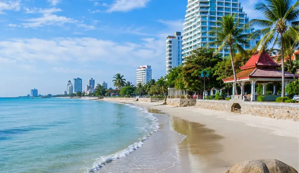 Hua Hin Beach Thailand with calm blue sea, soft sandy shore, luxury resorts, palm trees, and bright morning atmosphere.