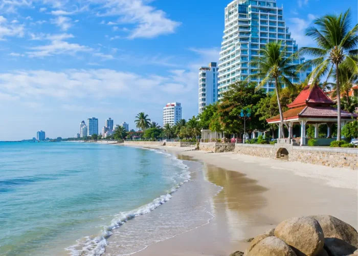 Hua Hin Beach Thailand with calm blue sea, soft sandy shore, luxury resorts, palm trees, and bright morning atmosphere.