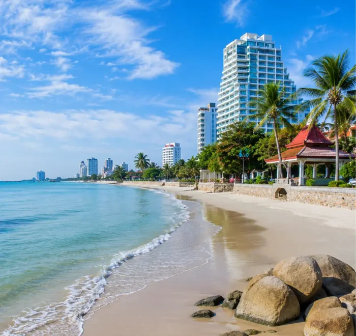 Hua Hin Beach Thailand with calm blue sea, soft sandy shore, luxury resorts, palm trees, and bright morning atmosphere.