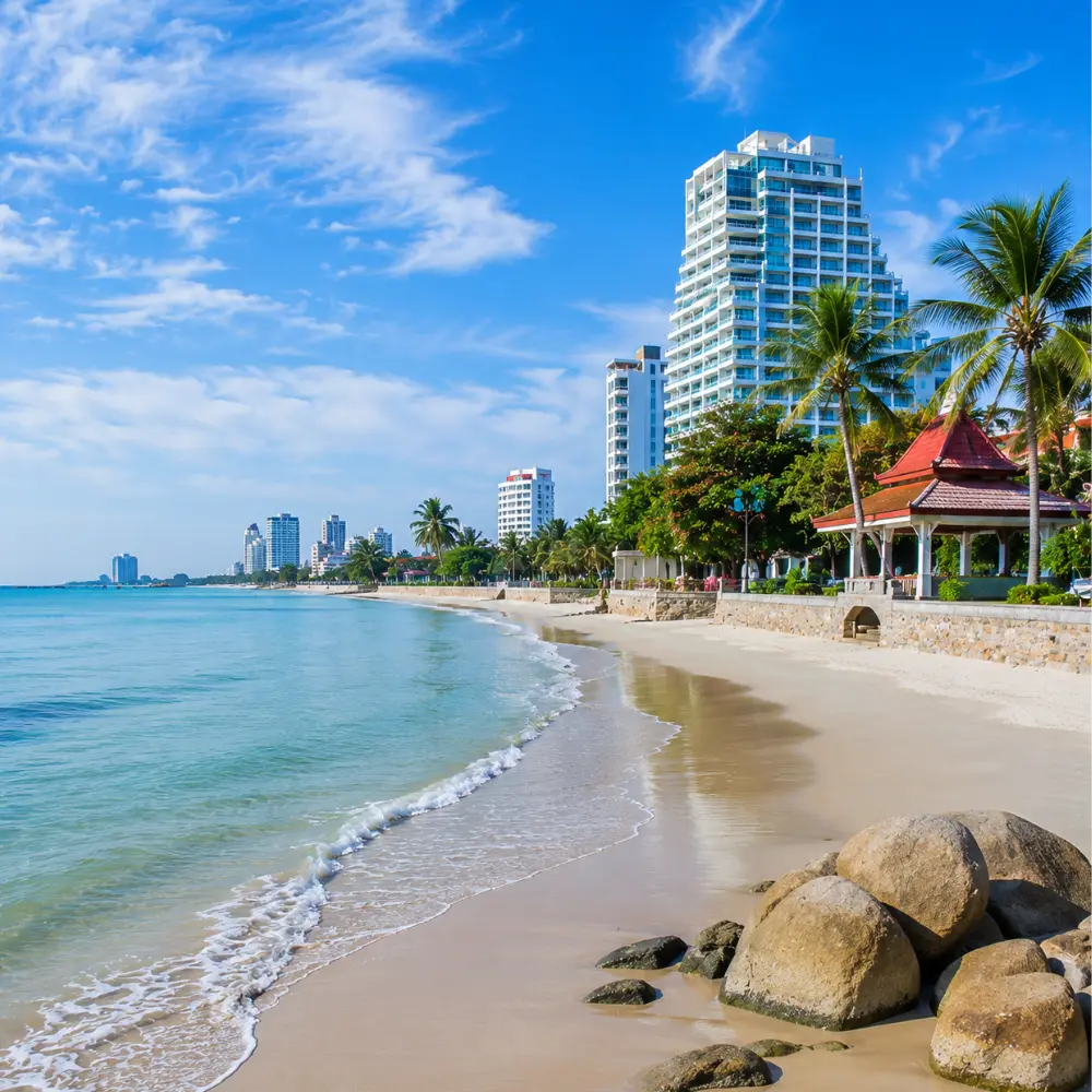 Hua Hin Beach Thailand with calm blue sea, soft sandy shore, luxury resorts, palm trees, and bright morning atmosphere.