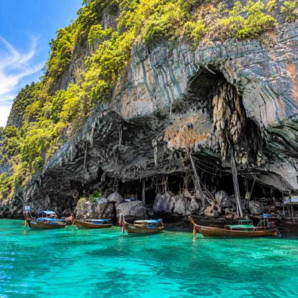 Phi Phi Viking Cave Thailand with limestone cliffs, turquoise sea, boat views, and bright morning island atmosphere.