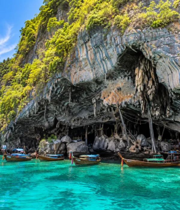 Phi Phi Viking Cave Thailand with limestone cliffs, turquoise sea, boat views, and bright morning island atmosphere.