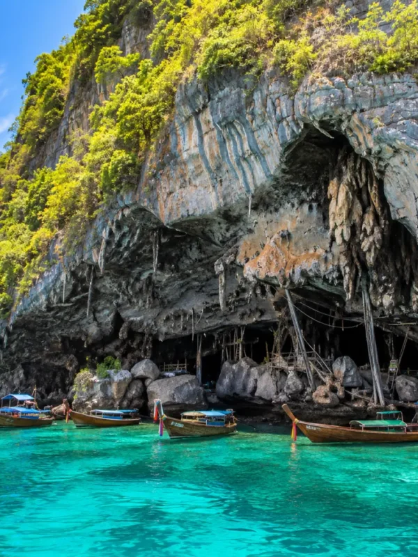 Phi Phi Viking Cave Thailand with limestone cliffs, turquoise sea, boat views, and bright morning island atmosphere.