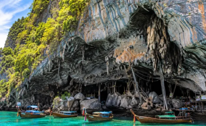 Phi Phi Viking Cave Thailand with limestone cliffs, turquoise sea, boat views, and bright morning island atmosphere.