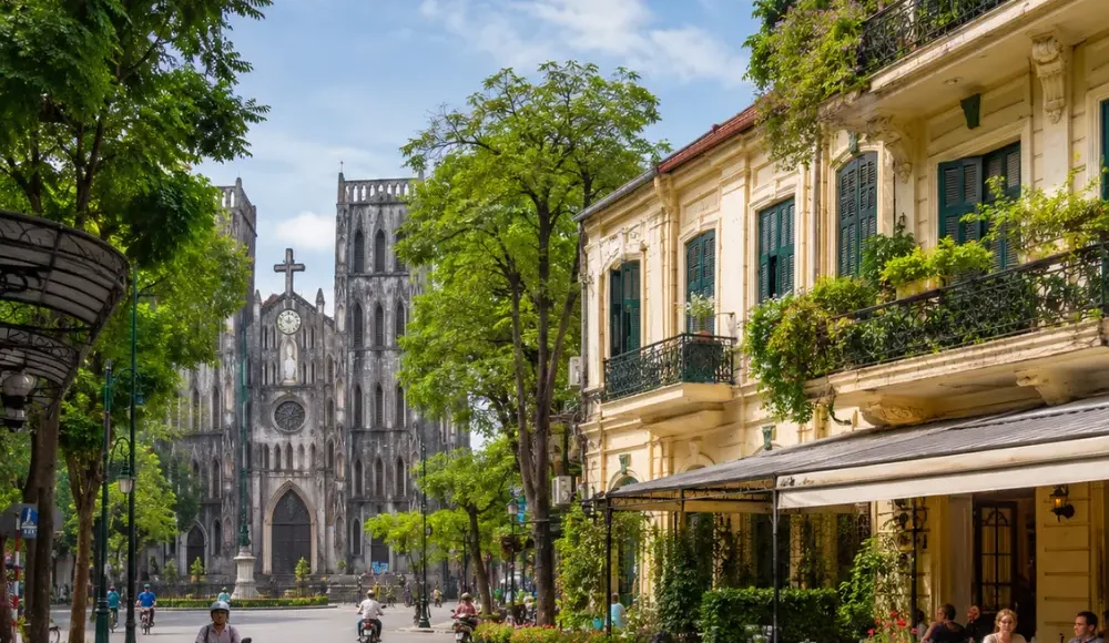 Hanoi street view with St. Joseph’s Cathedral, colonial buildings, green trees, and a bright luxury travel atmosphere.