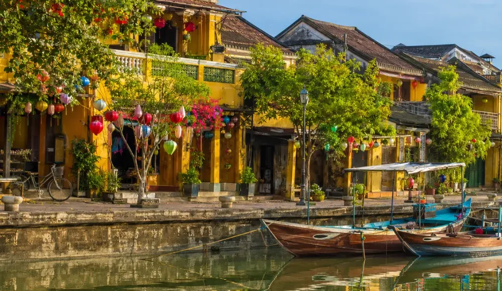 Hoi An Vietnam ancient town with lantern-lit streets, yellow heritage houses, and a premium cultural travel atmosphere.