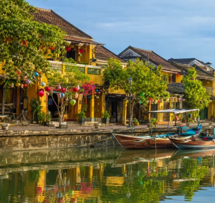 Hoi An Vietnam ancient town with lantern-lit streets, yellow heritage houses, and a premium cultural travel atmosphere.