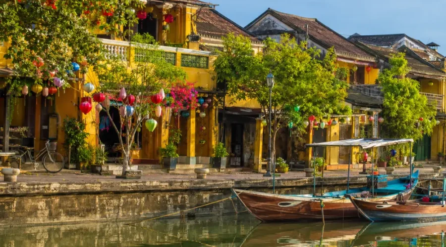 Hoi An Vietnam ancient town with lantern-lit streets, yellow heritage houses, and a premium cultural travel atmosphere.