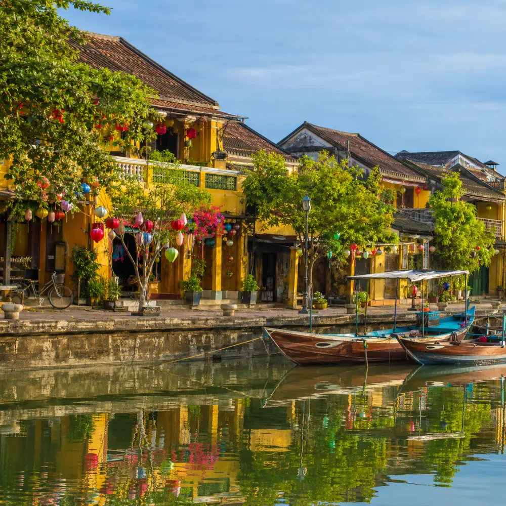 Hoi An Vietnam ancient town with lantern-lit streets, yellow heritage houses, and a premium cultural travel atmosphere.