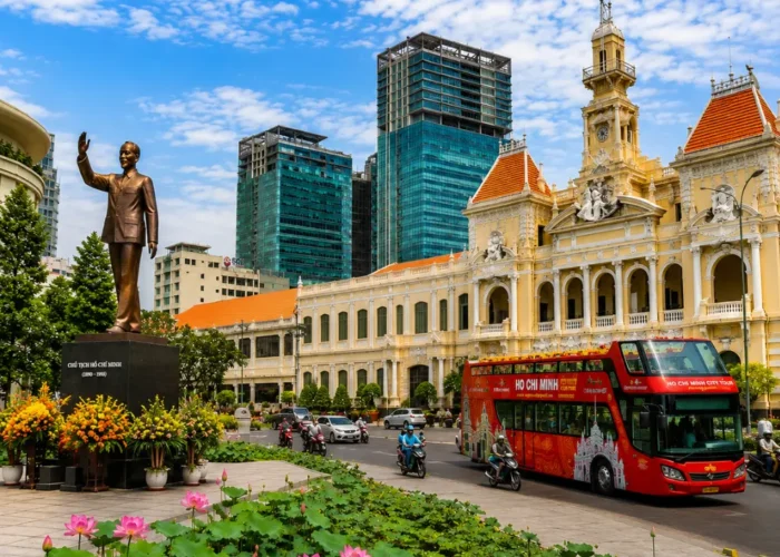 Ho Chi Minh City tour with City Hall, Ho Chi Minh statue, lotus garden, sightseeing bus, and modern Saigon skyline.
