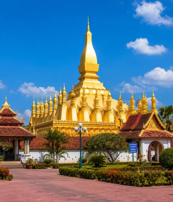 Vientiane Laos with Pha That Luang golden stupa, peaceful gardens, blue sky, and a premium cultural travel atmosphere.
