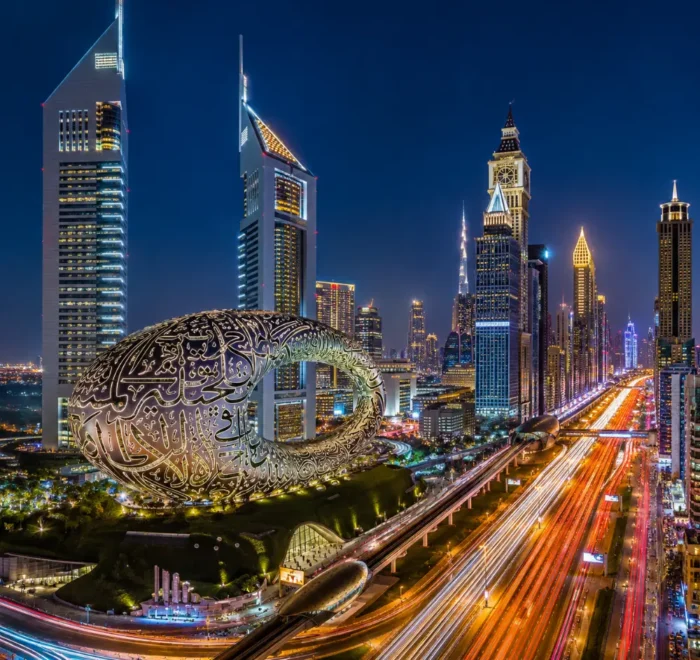 Dubai night skyline with Museum of the Future, glowing city lights, futuristic towers, and a premium luxury travel atmosphere.