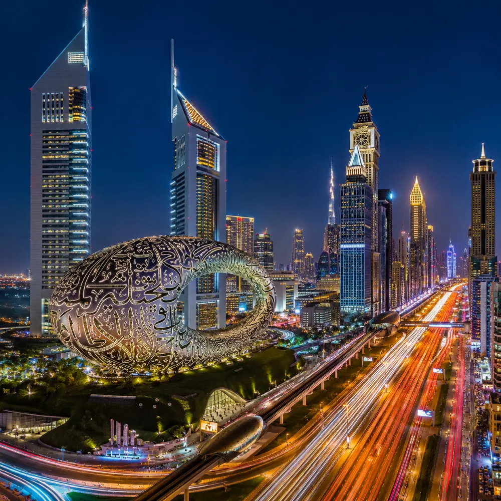 Dubai night skyline with Museum of the Future, glowing city lights, futuristic towers, and a premium luxury travel atmosphere.