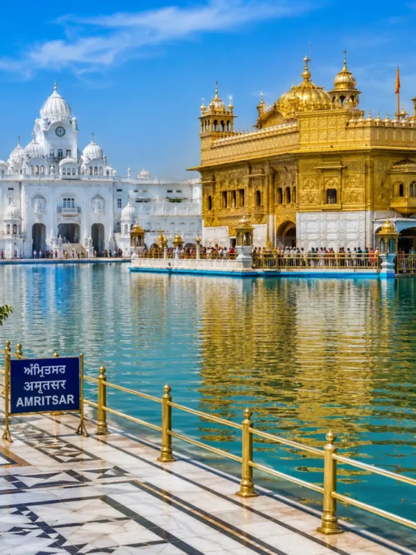 Amritsar Golden Temple with sacred pool reflections, Sikh architecture and clear morning daylight in Punjab.