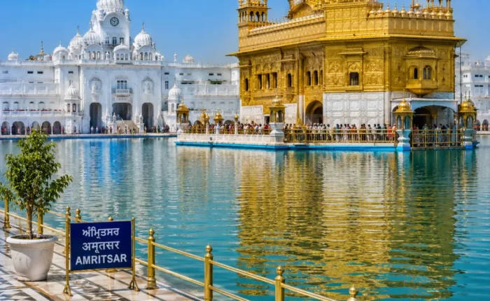 Amritsar Golden Temple with sacred pool reflections, Sikh architecture and clear morning daylight in Punjab.