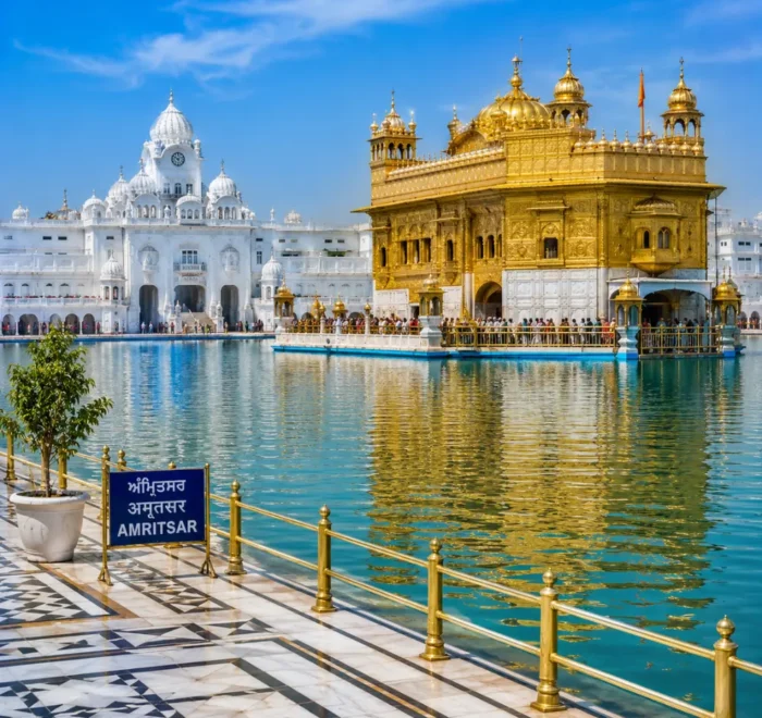 Amritsar Golden Temple with sacred pool reflections, Sikh architecture and clear morning daylight in Punjab.