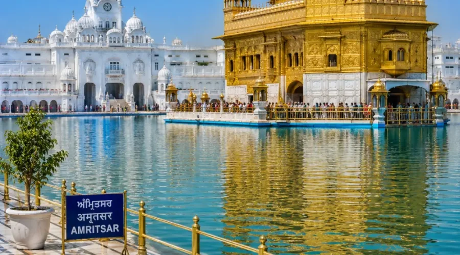 Amritsar Golden Temple with sacred pool reflections, Sikh architecture and clear morning daylight in Punjab.